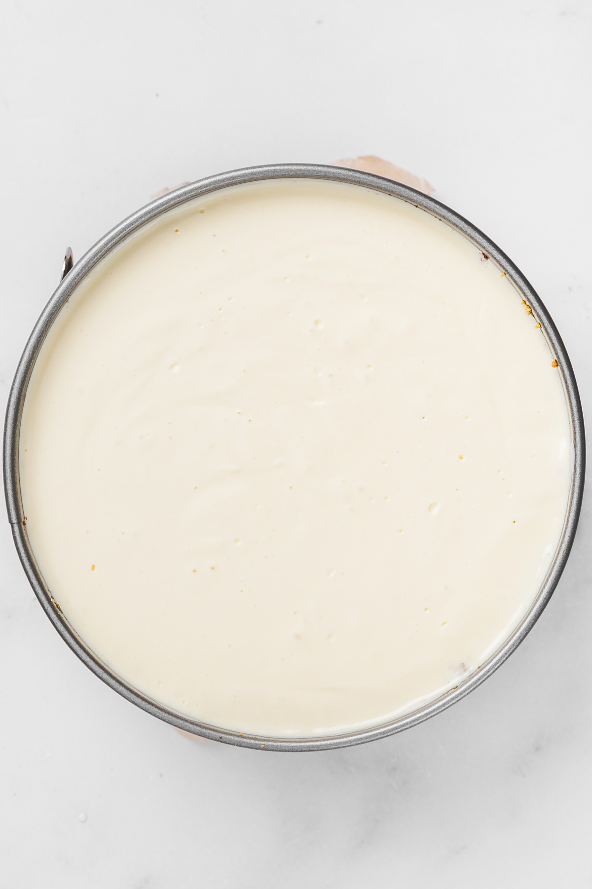 Filling springform pan with smooth lemon cheesecake batter