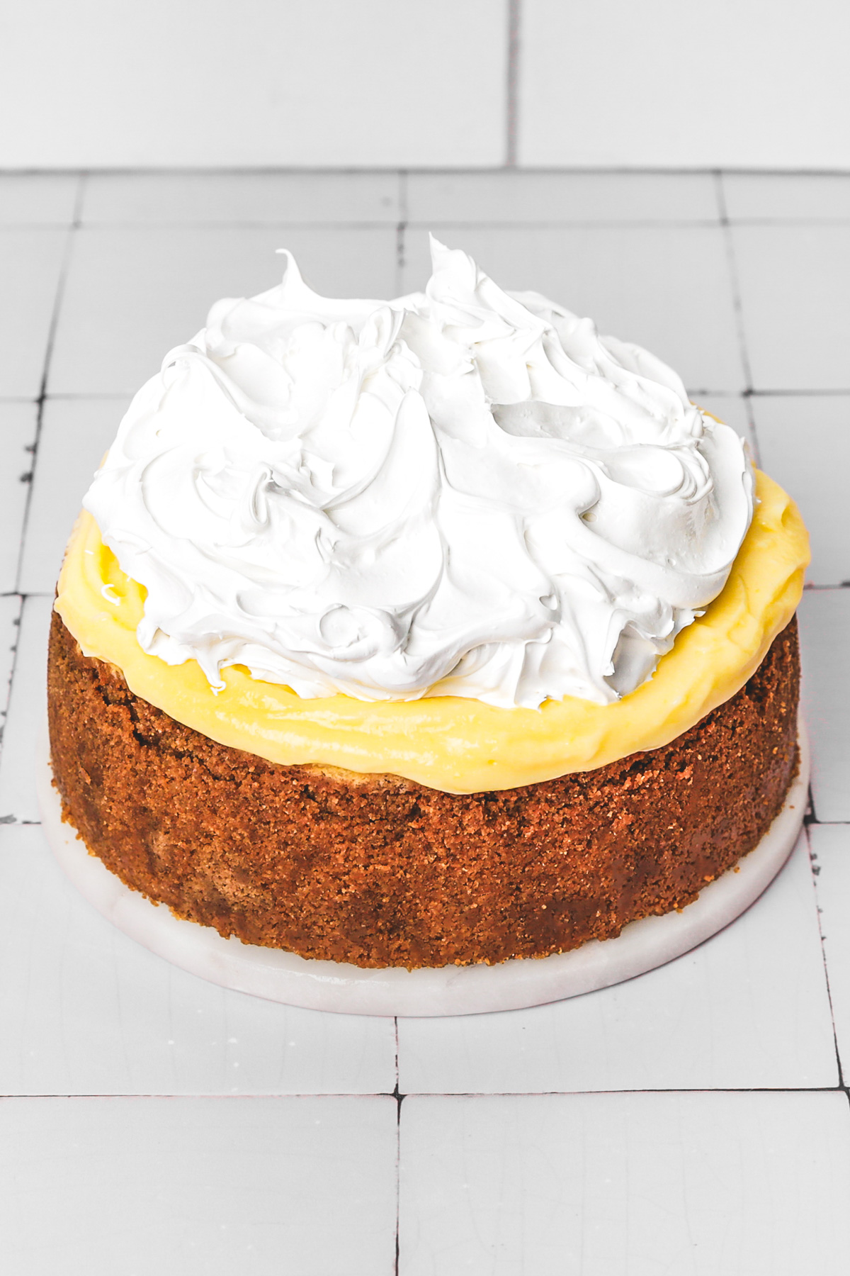 Finished lemon meringue cheesecake topped with golden meringue and lemon curd