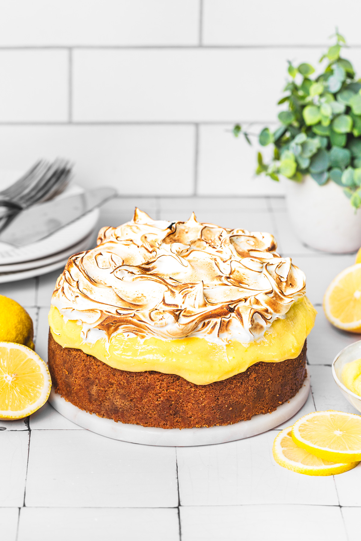 Slice of lemon meringue cheesecake on a plate with toasted meringue and lemon curd topping