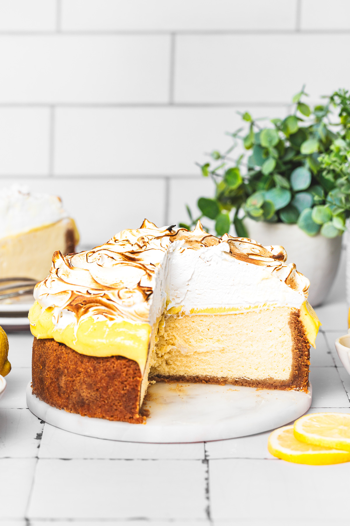 Clean slice of lemon cheesecake with meringue topping and lemon curd layers