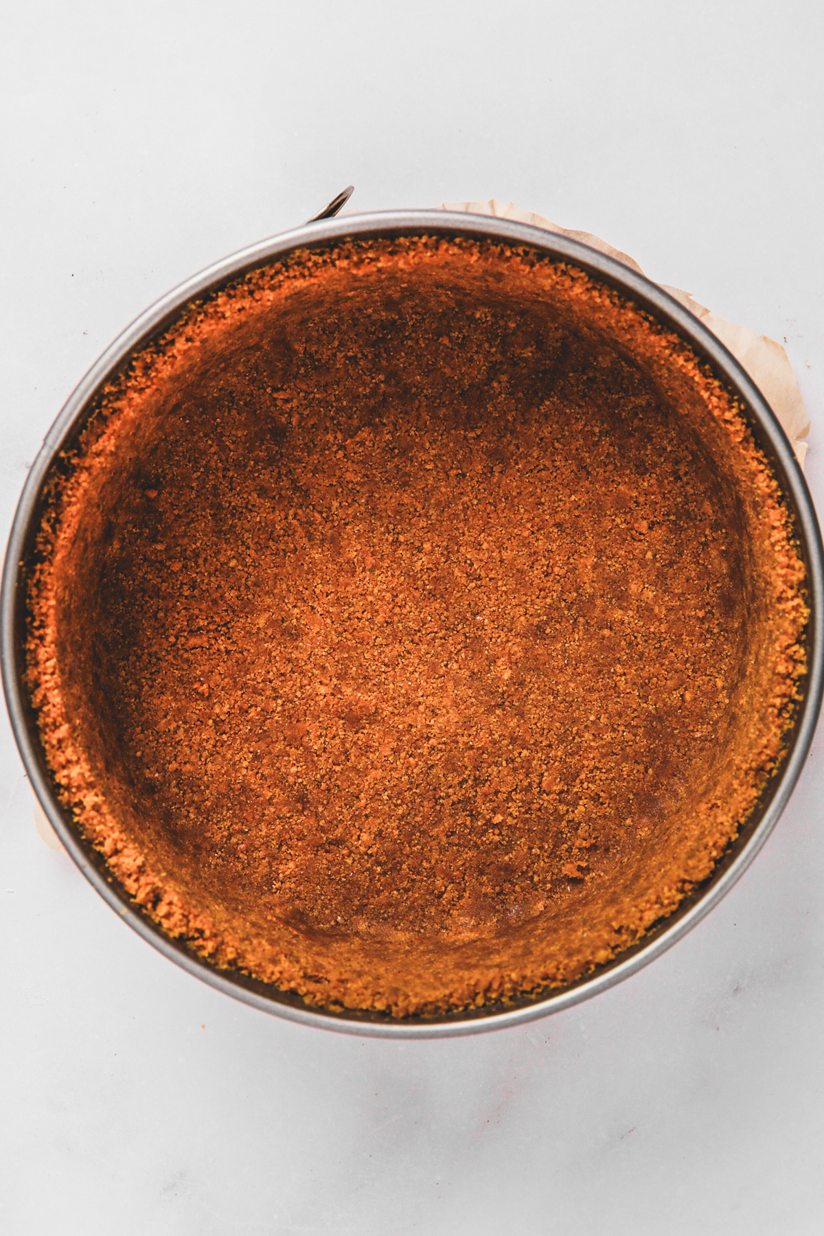 Graham cracker crust pressed into a springform pan ready to bake
