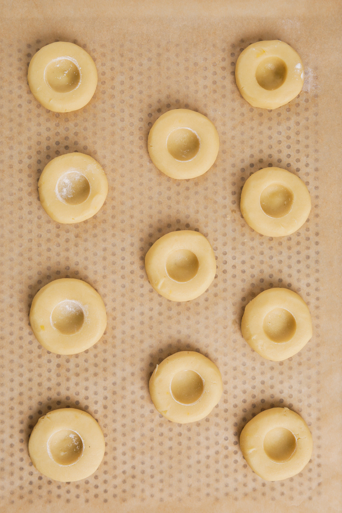 baking sheet with unbaked lemon thumbprint cookies