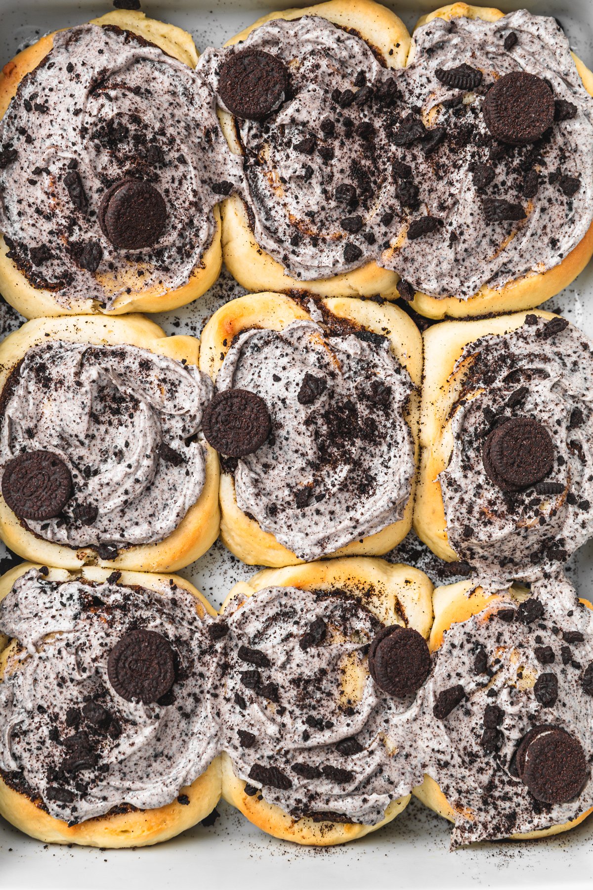 Baked Oreo cinnamon rolls topped with smooth cream cheese frosting and crushed Oreos