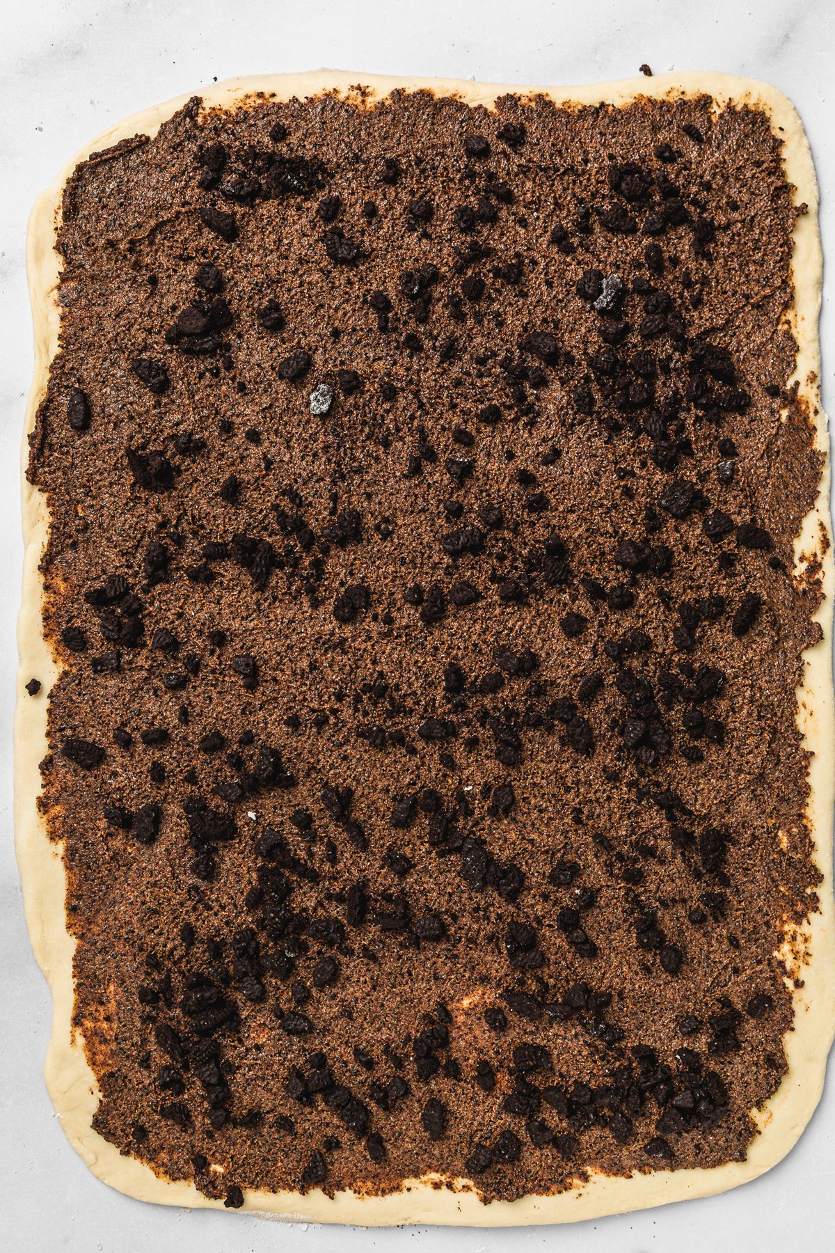 Brioche dough rolled out and covered with Oreo cinnamon sugar mixture