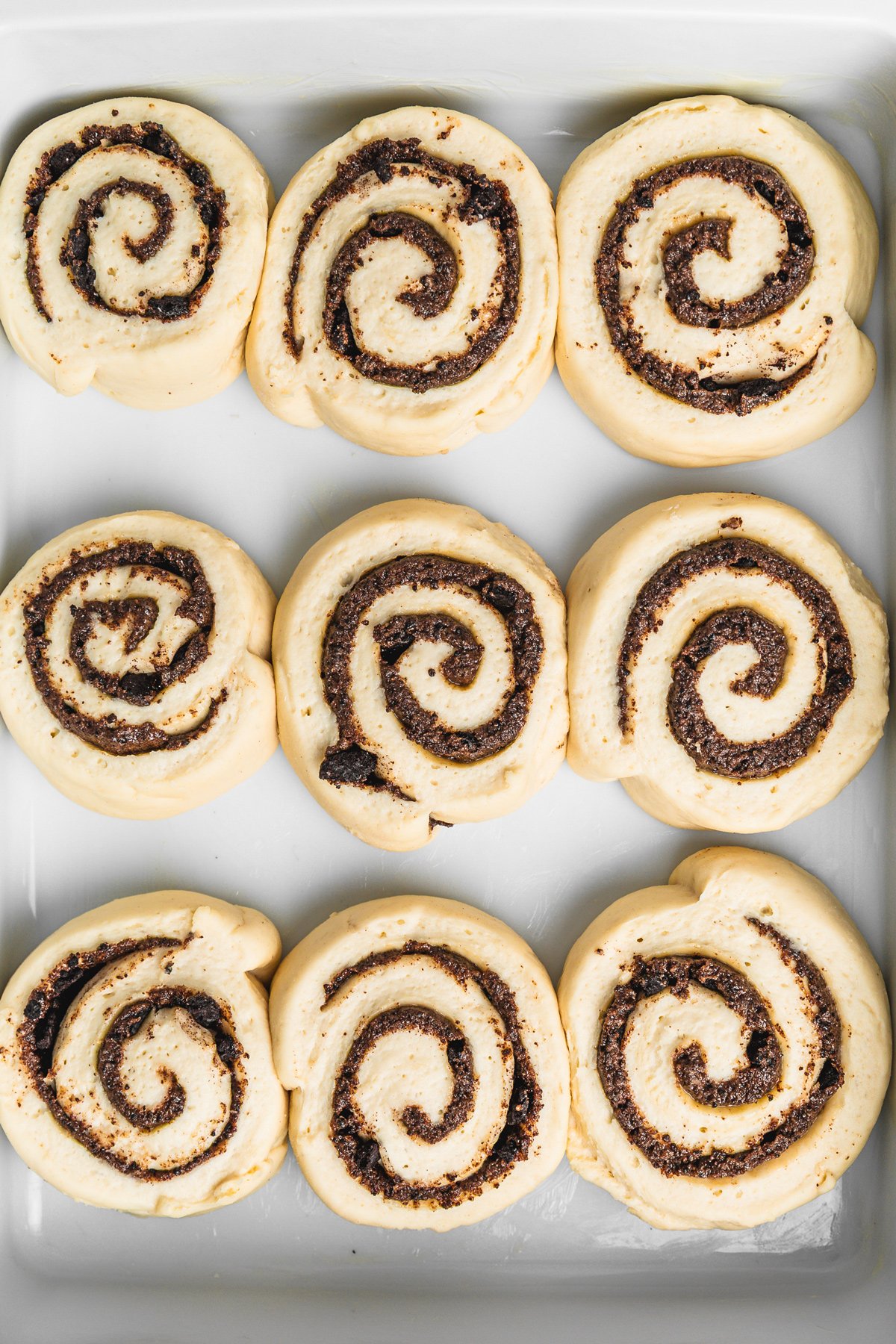 Unbaked Oreo cinnamon rolls after first rise in a dish, ready to bake