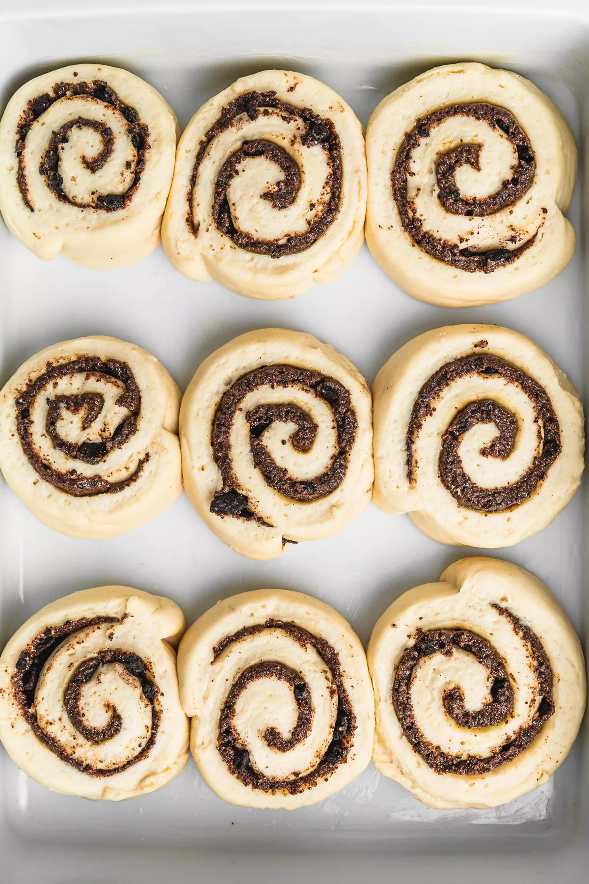 Unbaked Oreo cinnamon rolls after first rise in a dish, ready to bake