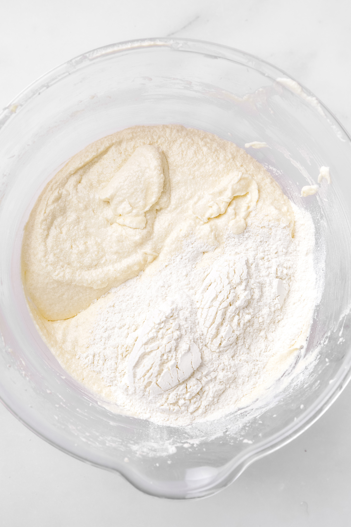 rainbow cupcake batter with flour mixture in a mixing bowl