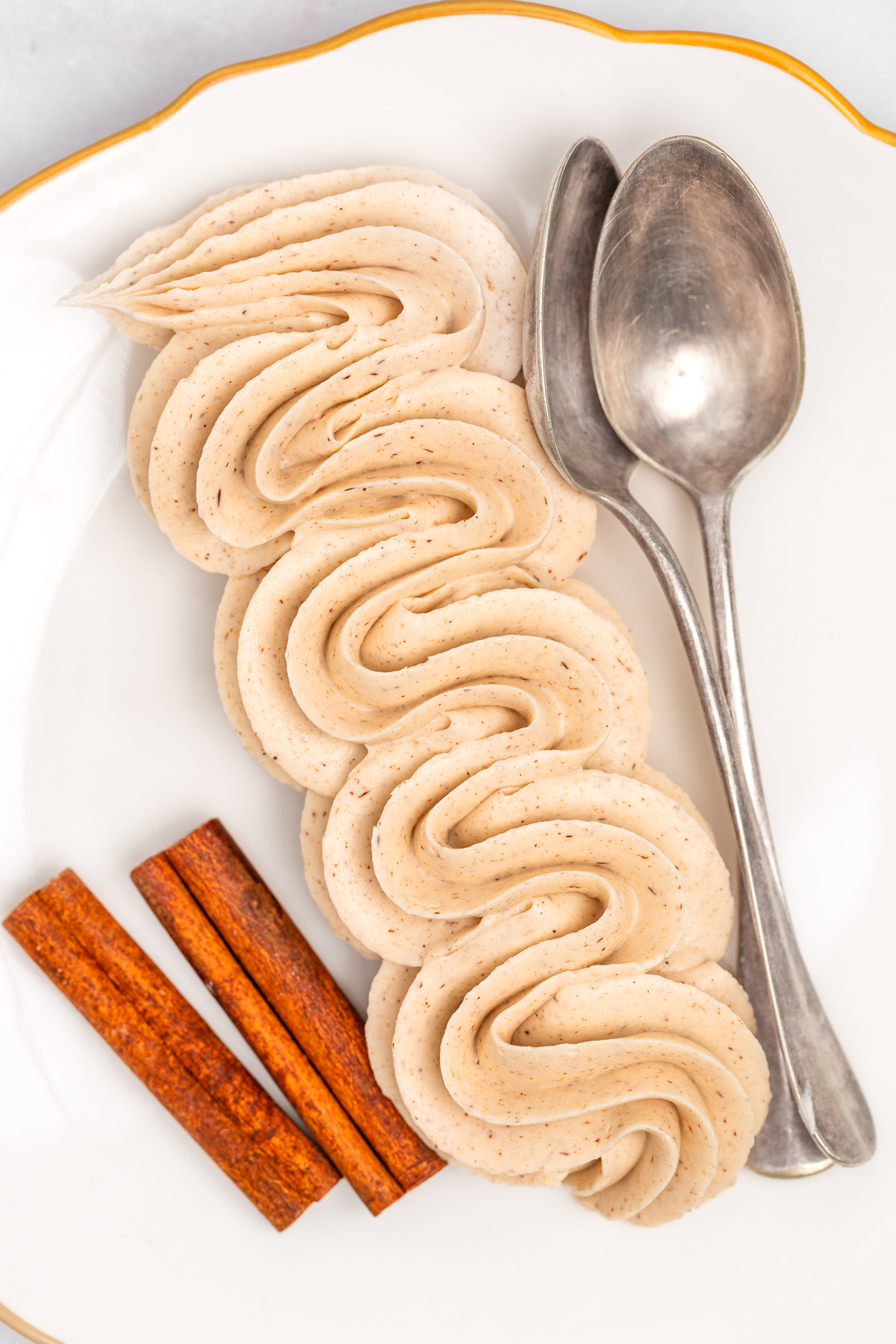 Cinnamon buttercream frosting piped with a piping bag