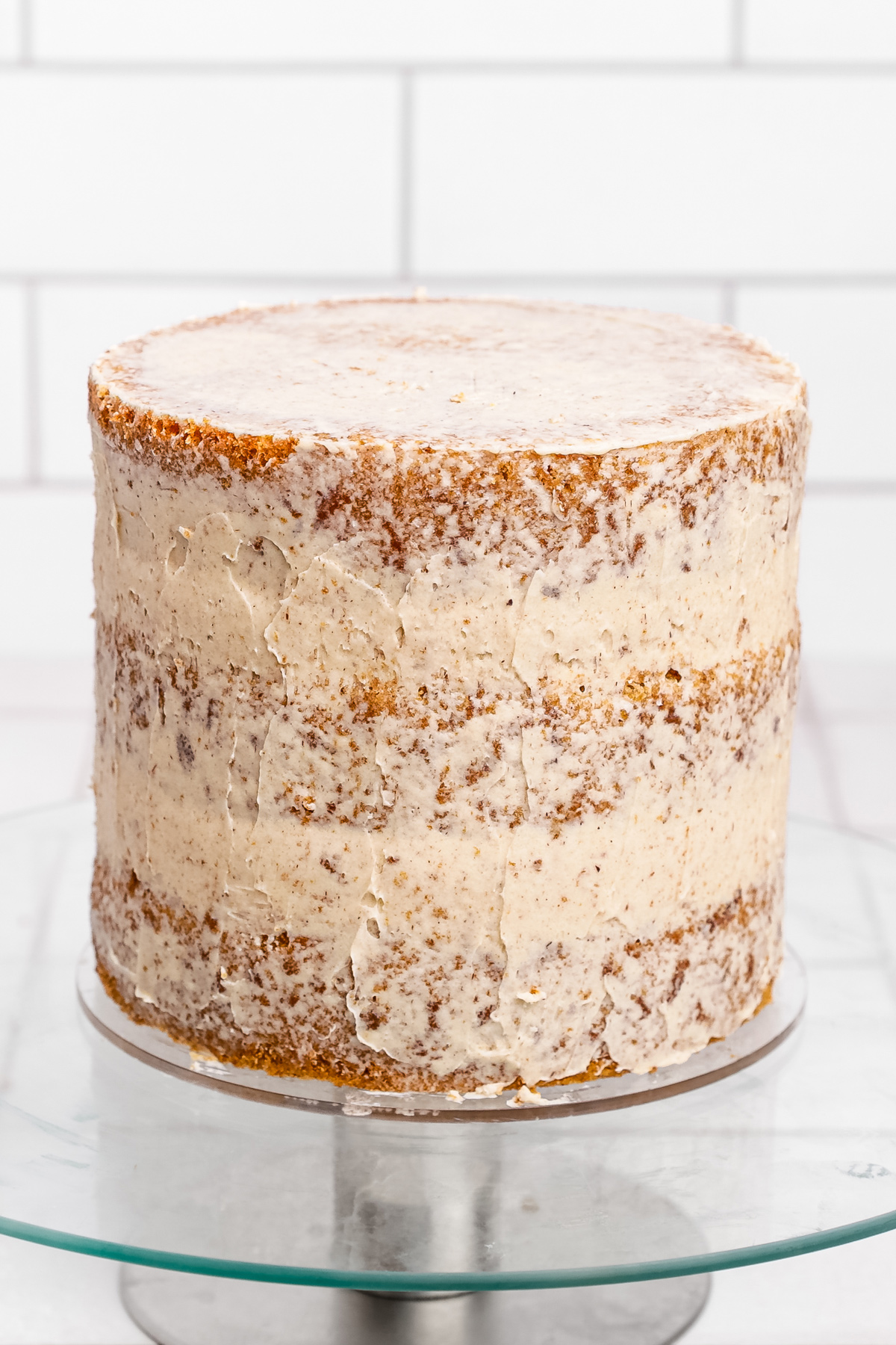 Layered cinnamon roll cake being assembled on a turntable