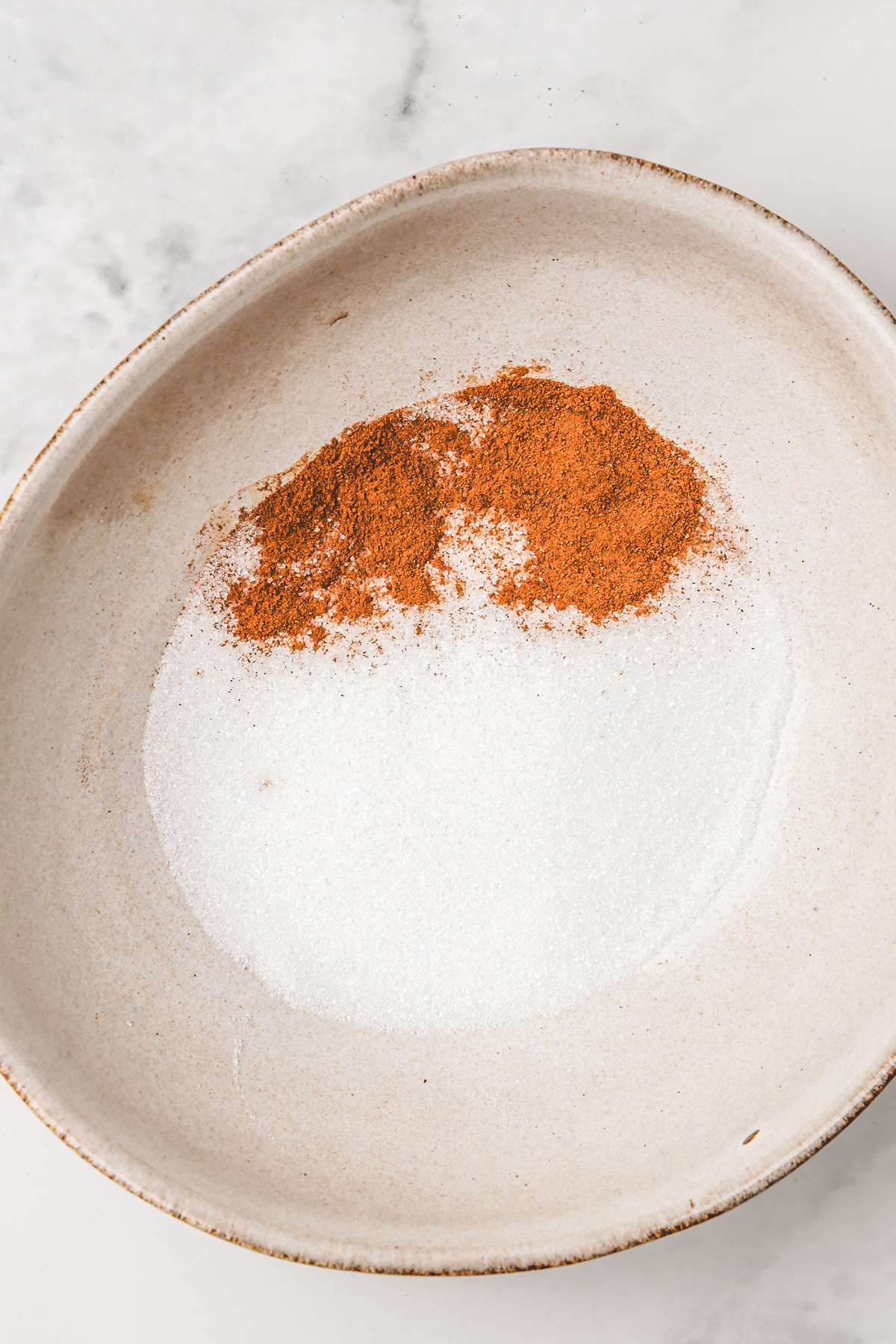 Bowl with sugar and ground cinnamon for coating