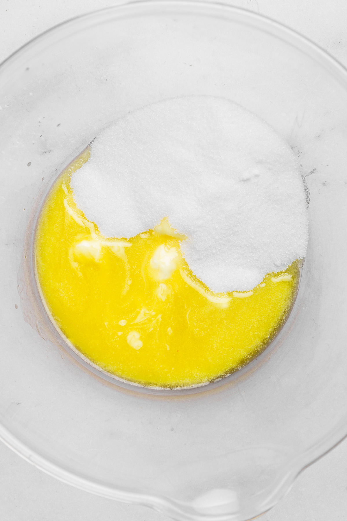 Bowl with melted butter and granulated sugar for chocolate cupcake batter