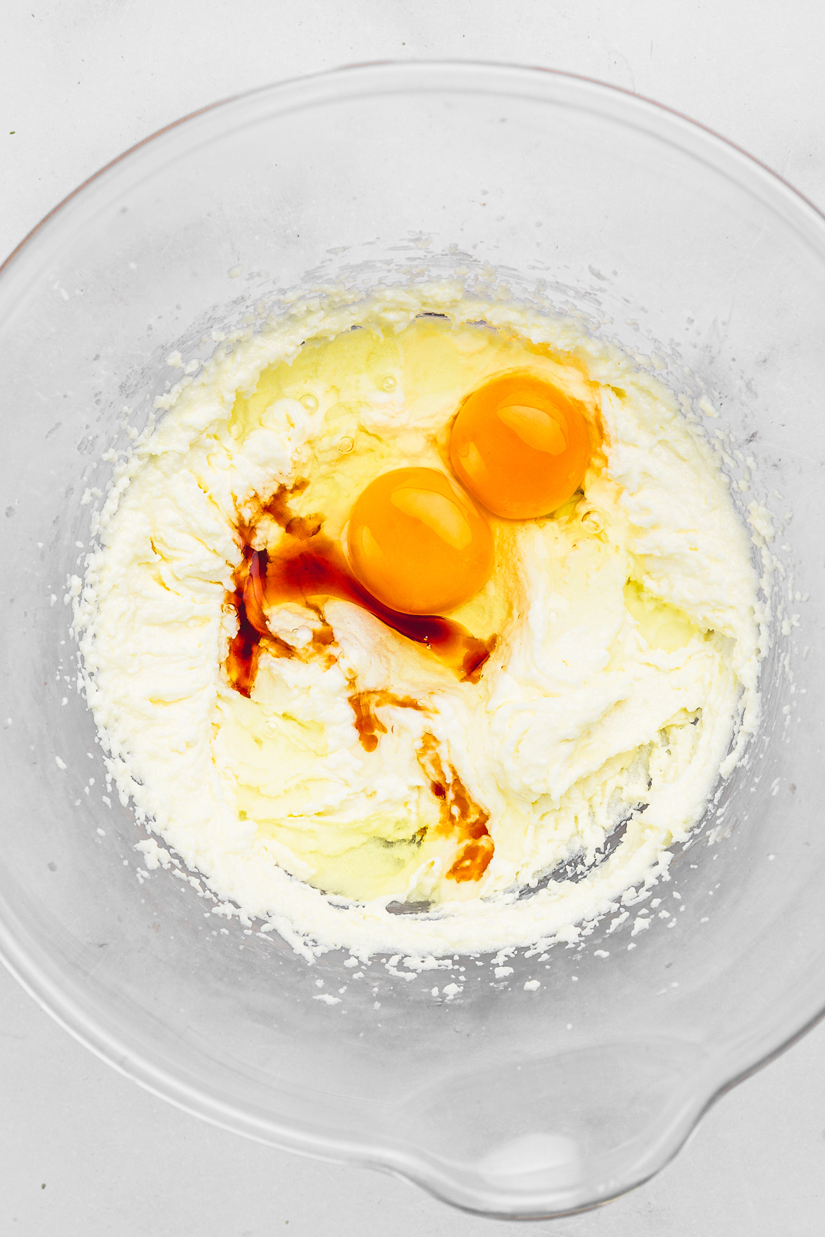 Mixing bowl with butter, sugar, eggs, and vanilla for chocolate cupcakes