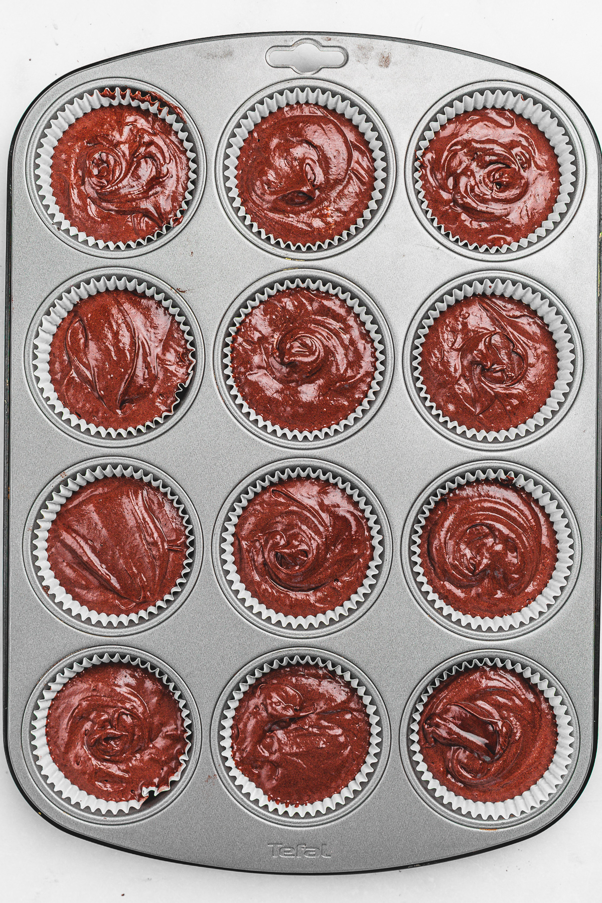 Cupcake pan filled with chocolate cupcake batter before baking