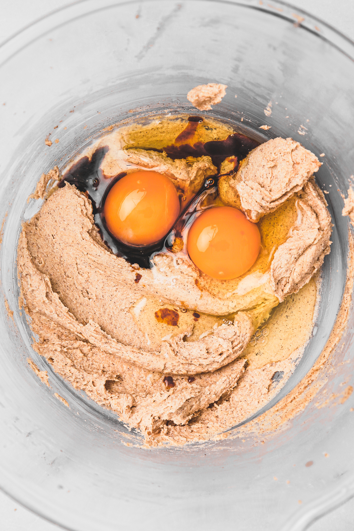 Egg vanilla butter and sugar being mixed in a bowl