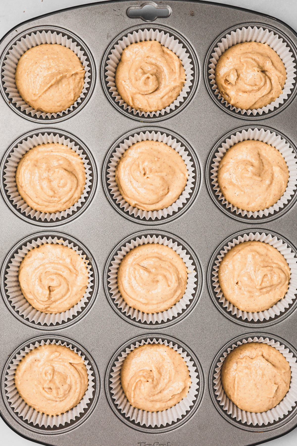 Freshly baked cinnamon cupcakes in a muffin tin