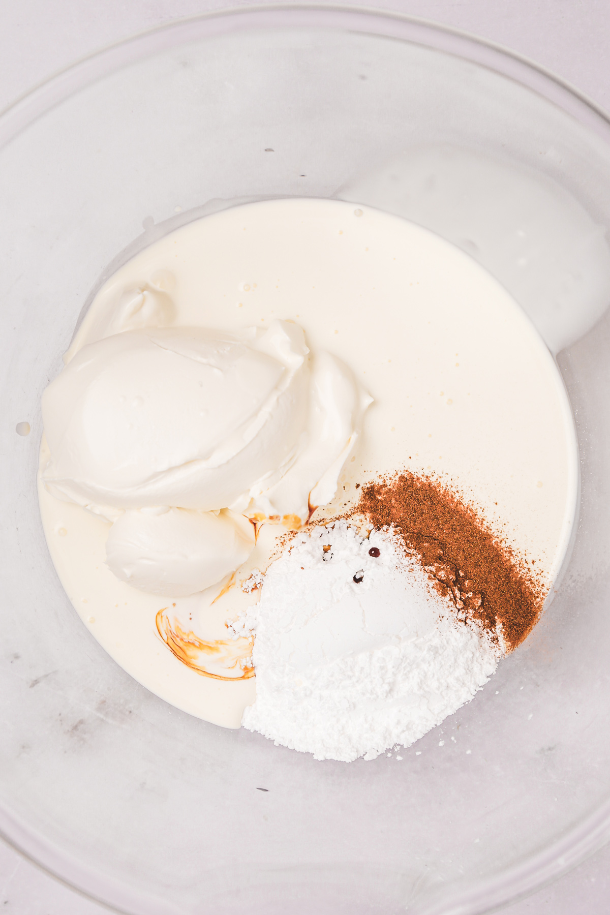 Mixing bowl with ingredients for cinnamon whipped cream frosting