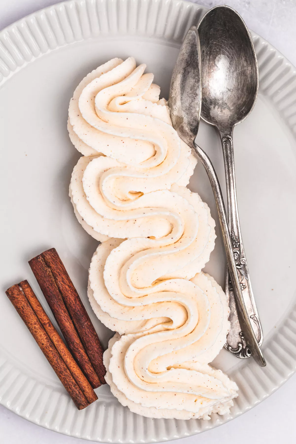 Cinnamon whipped cream frosting piped on a plate