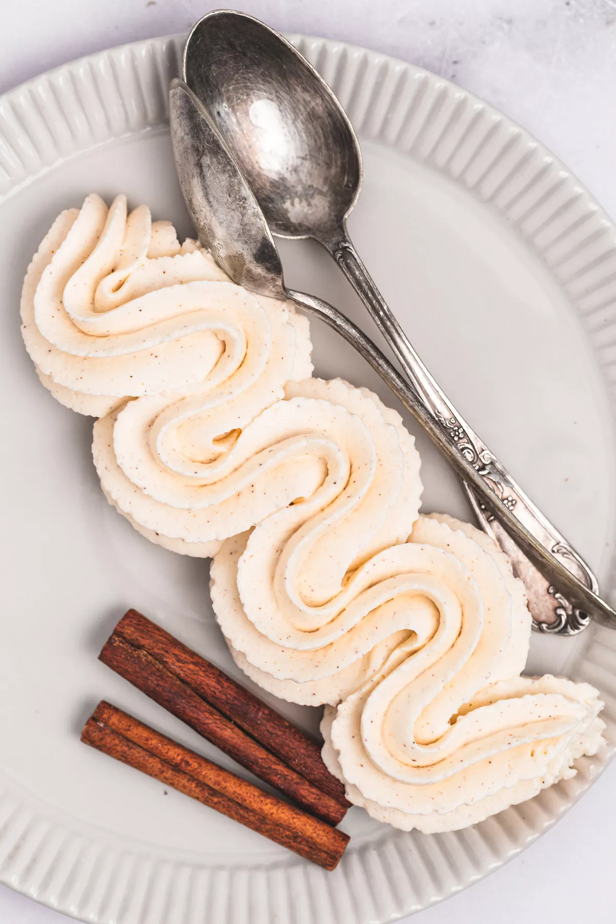 Piped cinnamon whipped cream frosting with pastry bag on a dessert plate