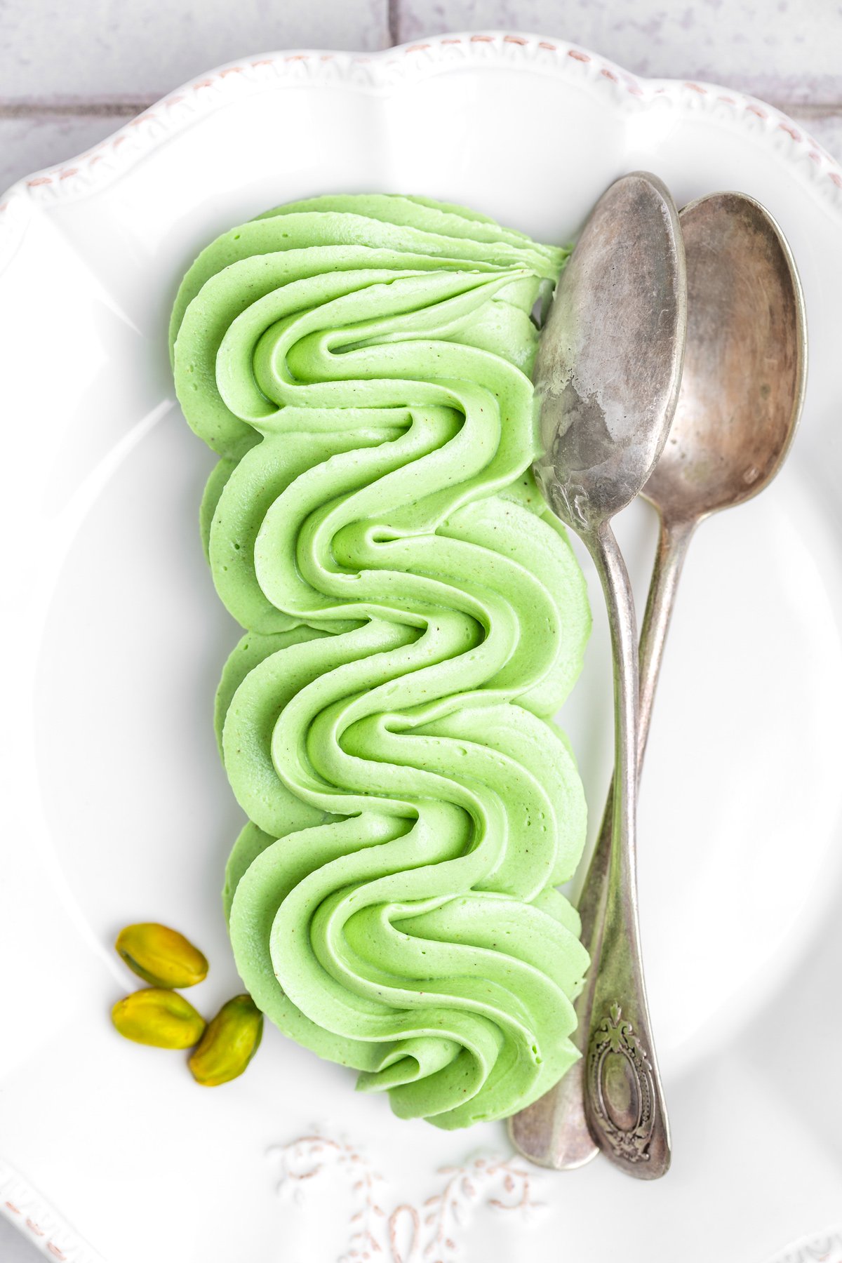 Pistachio buttercream frosting on a plate, smooth and creamy