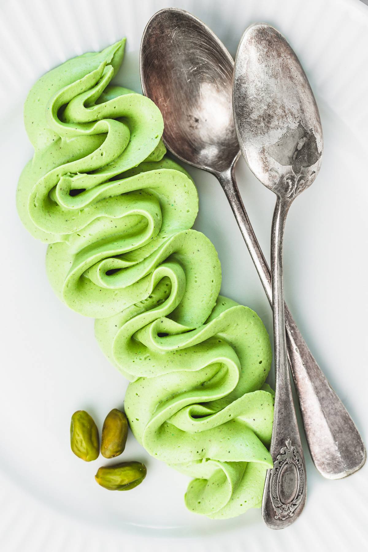 Dessert plate with pistachio ganache and small spoons for serving