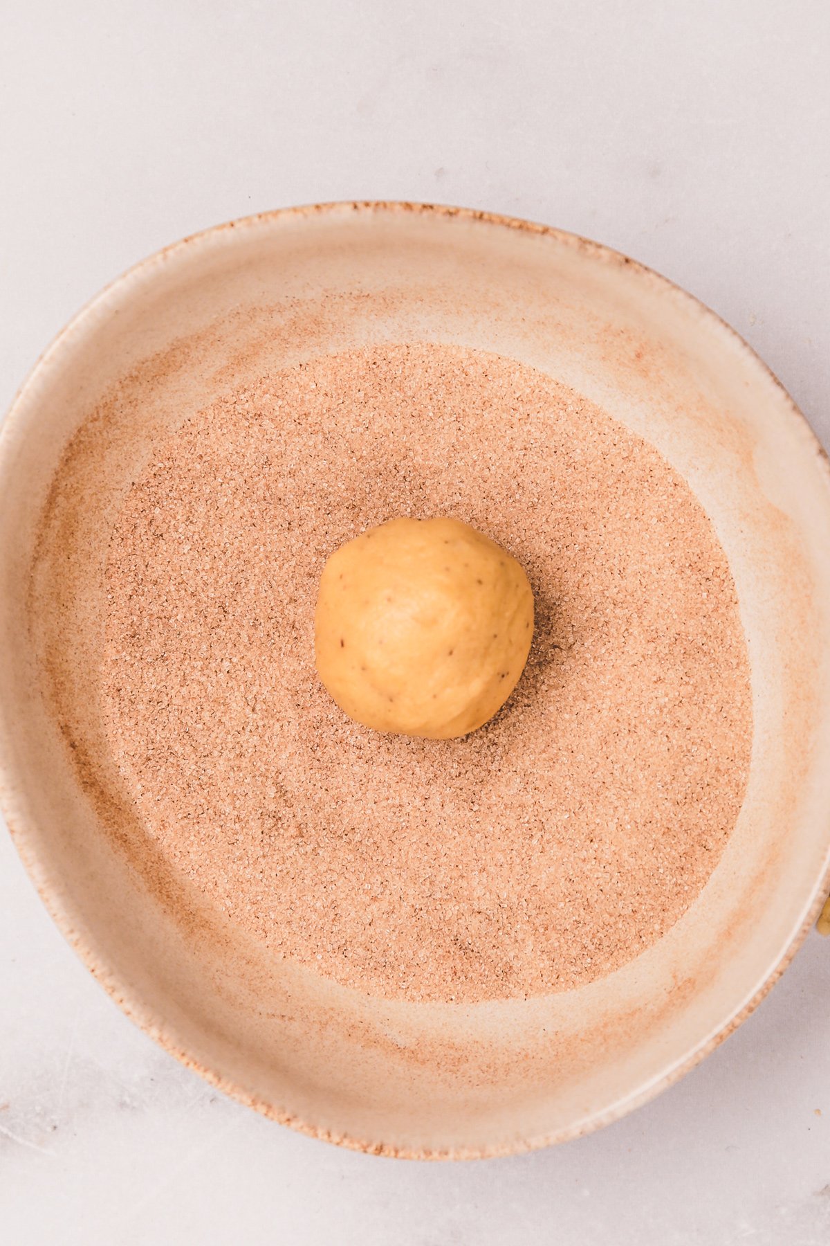 Bowl with cinnamon sugar and cookie dough ball