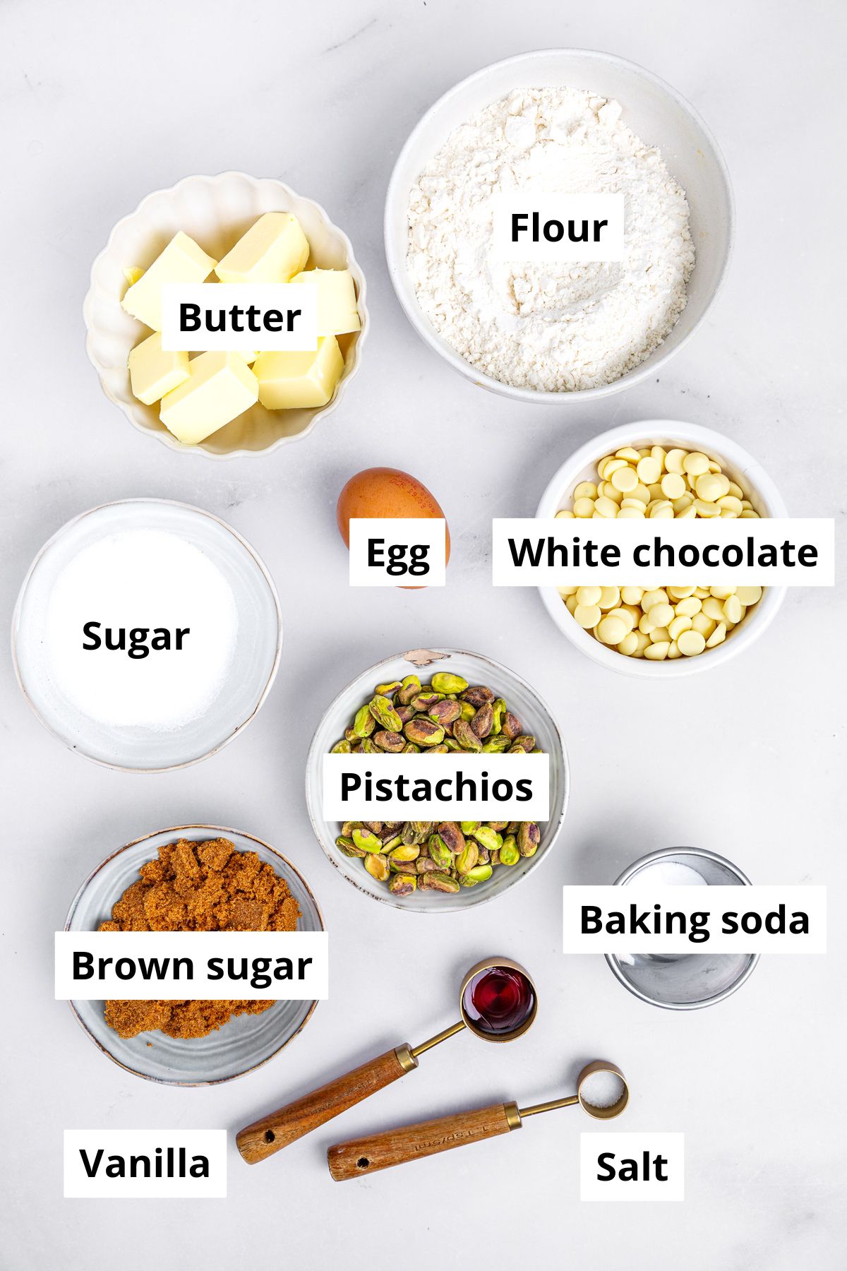 Bowls with ingredients to make white chocolate pistachio cookies