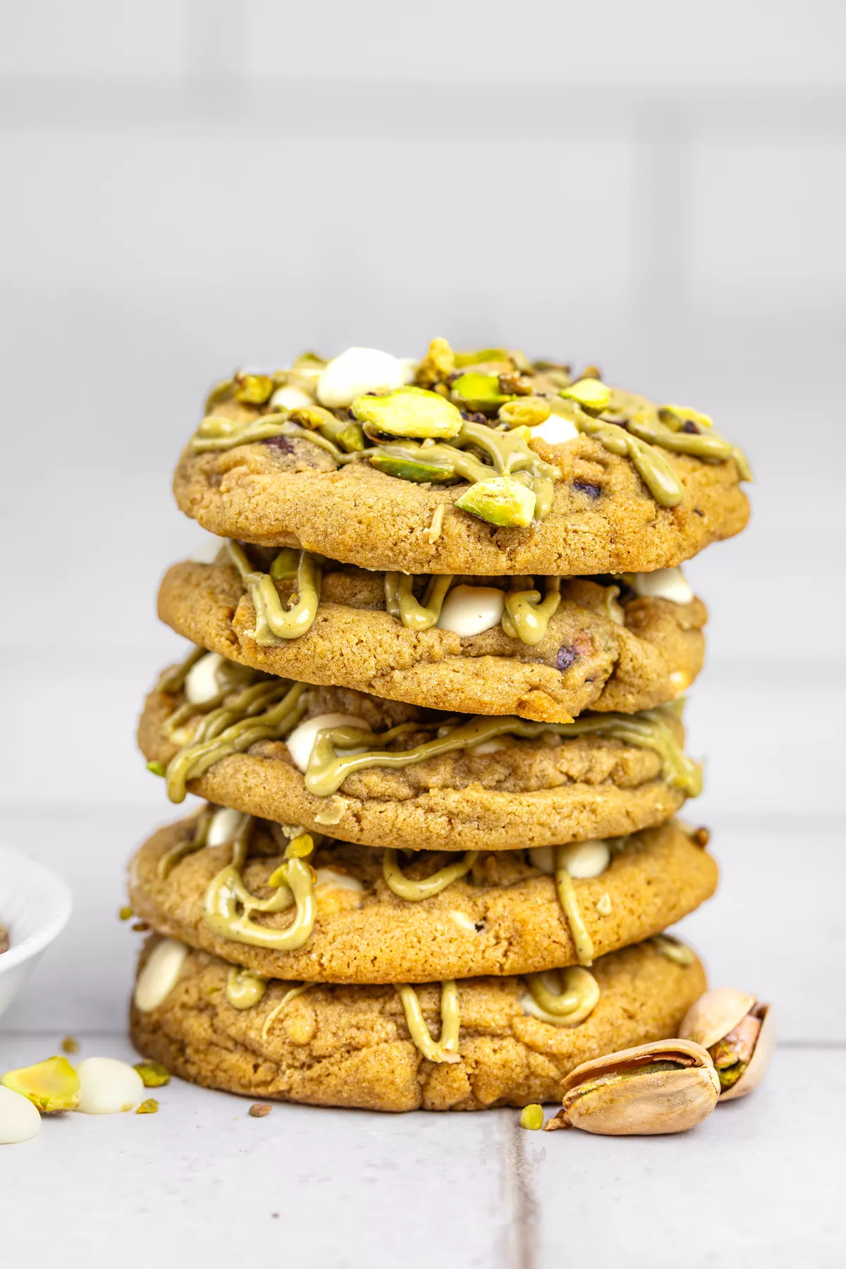 Stack of white chocolate pistachio cookies on a table