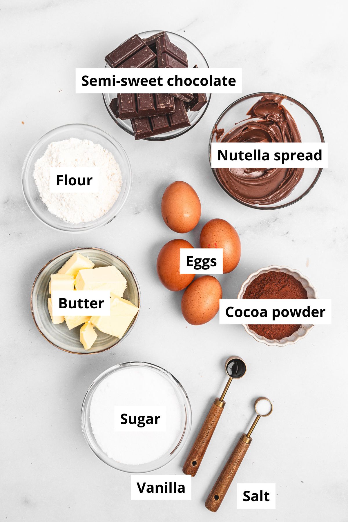  Bowls with ingredients for Nutella brownies – chocolate, butter, sugar, eggs, flour