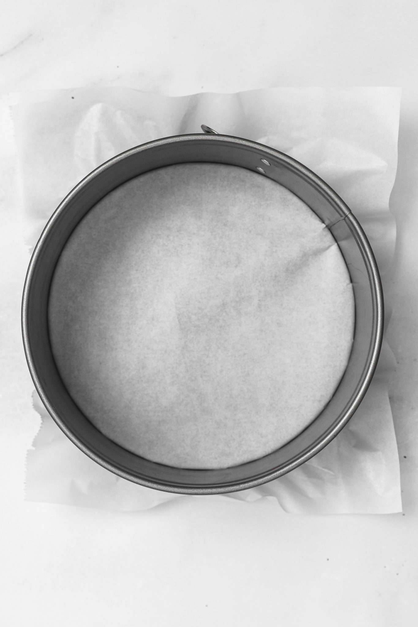Springform pan lined with parchment for cheesecake