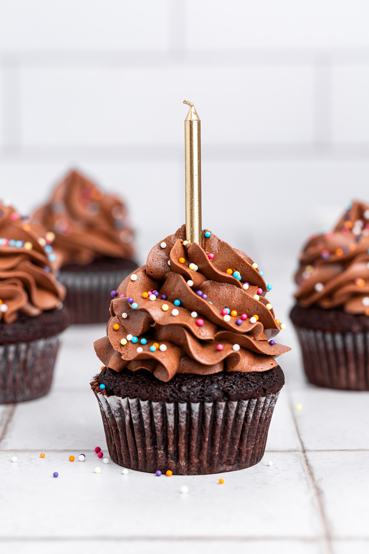 birthday chocolate cupcakes with sprinkles on a table