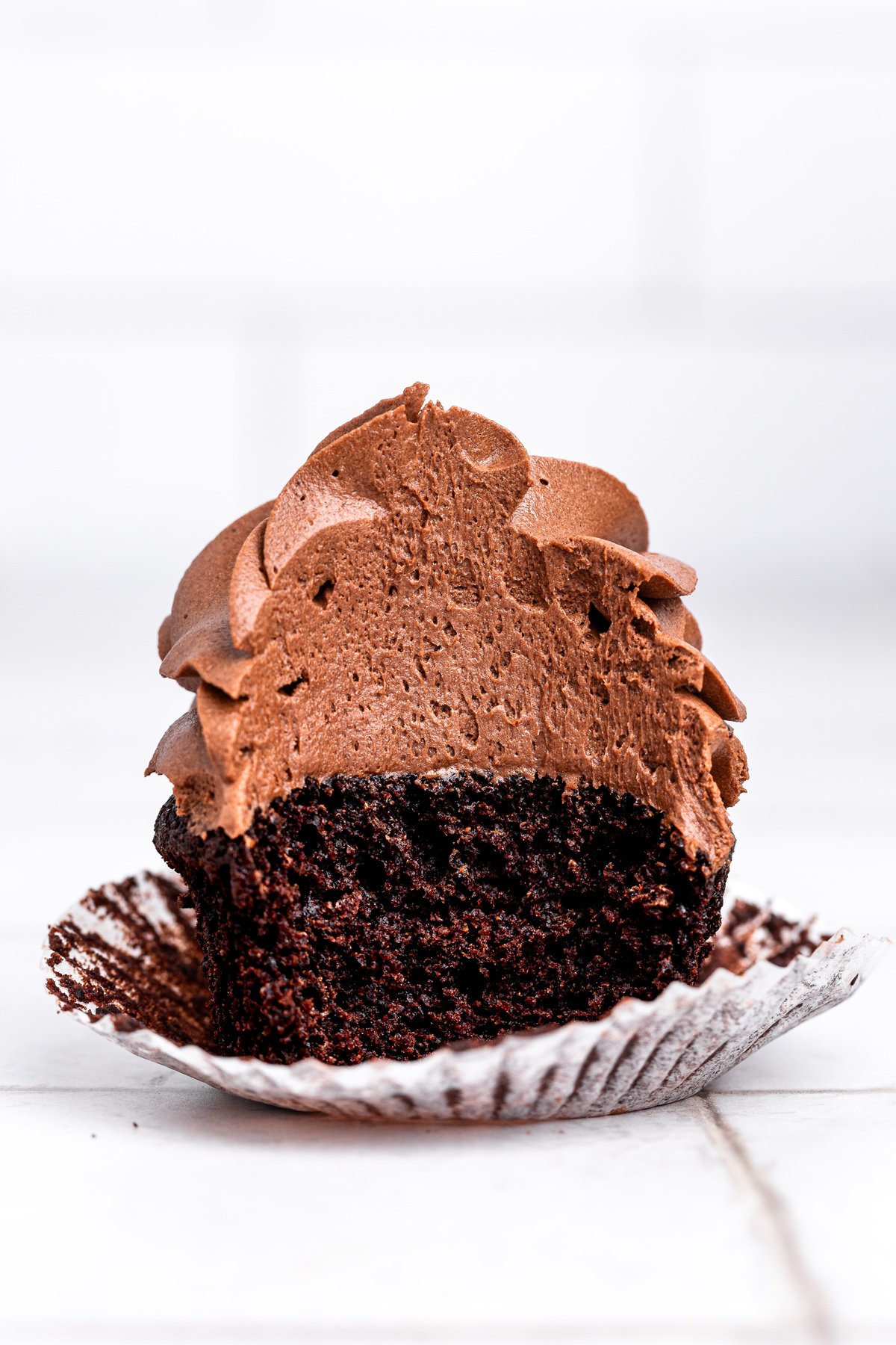 bitten chocolate cupcake showing soft chocolate crumb