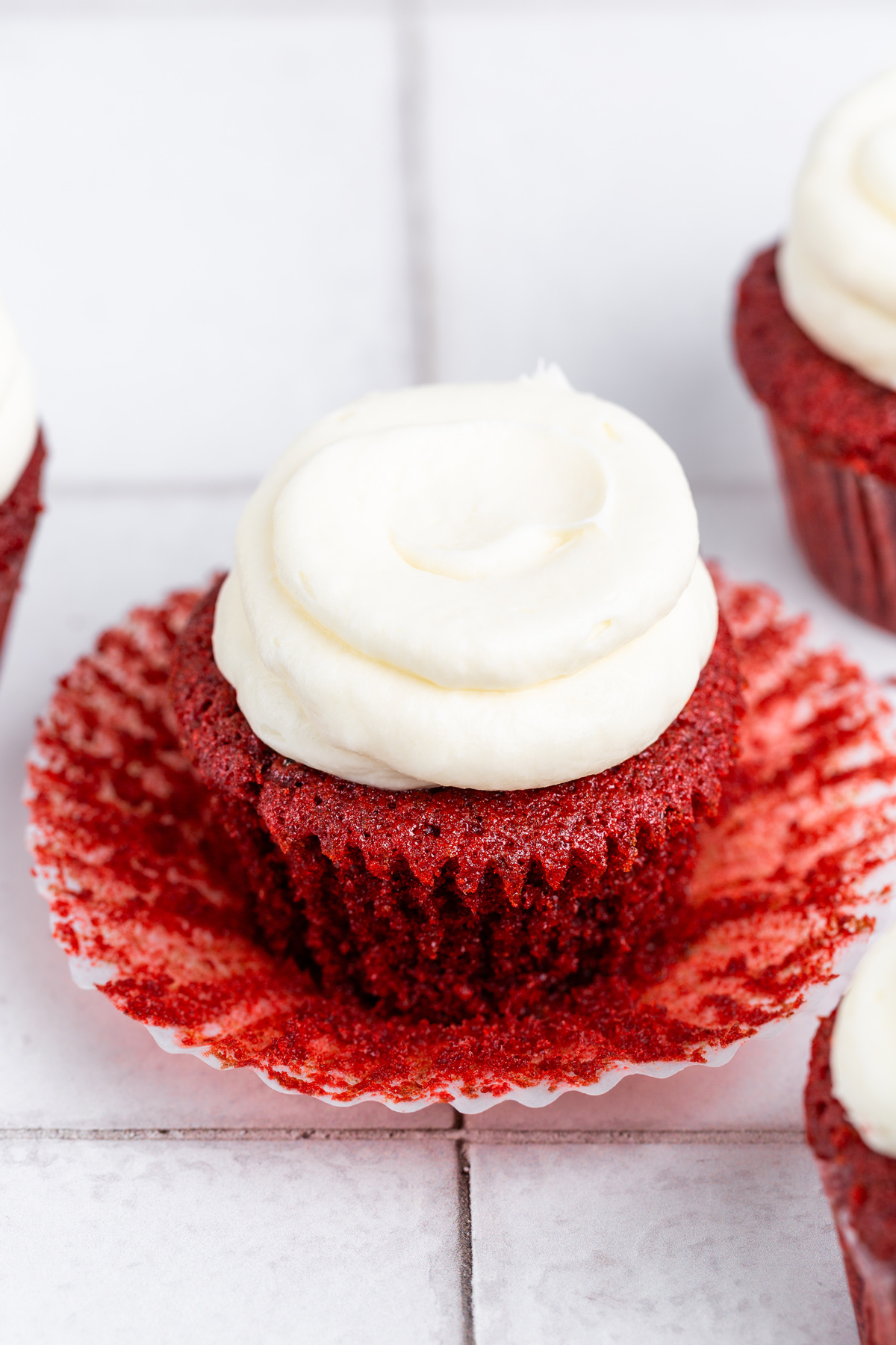 red velvet cupcakes with cream cheese frosting on a table