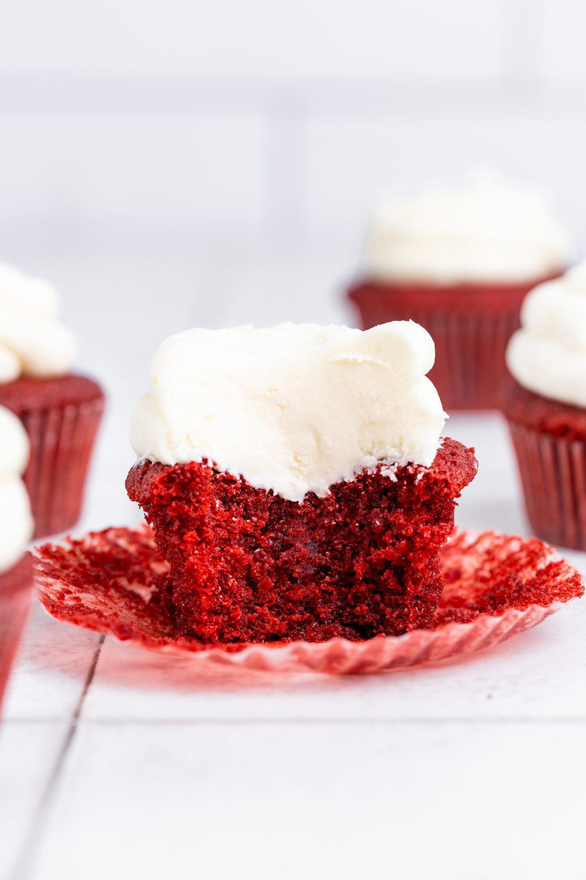 cut red velvet cupcake showing the soft crumb and frosting