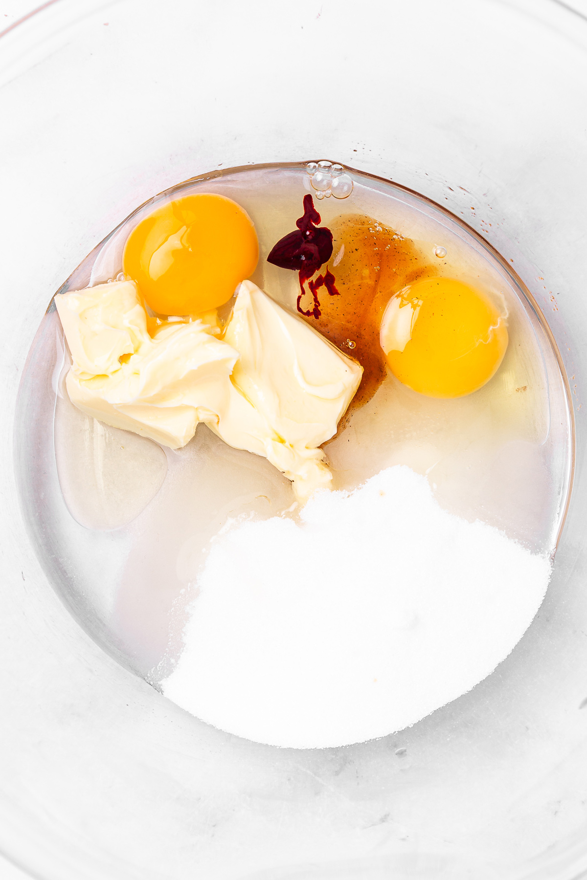 mixing butter oil egg sugar vanilla for red velvet cupcakes