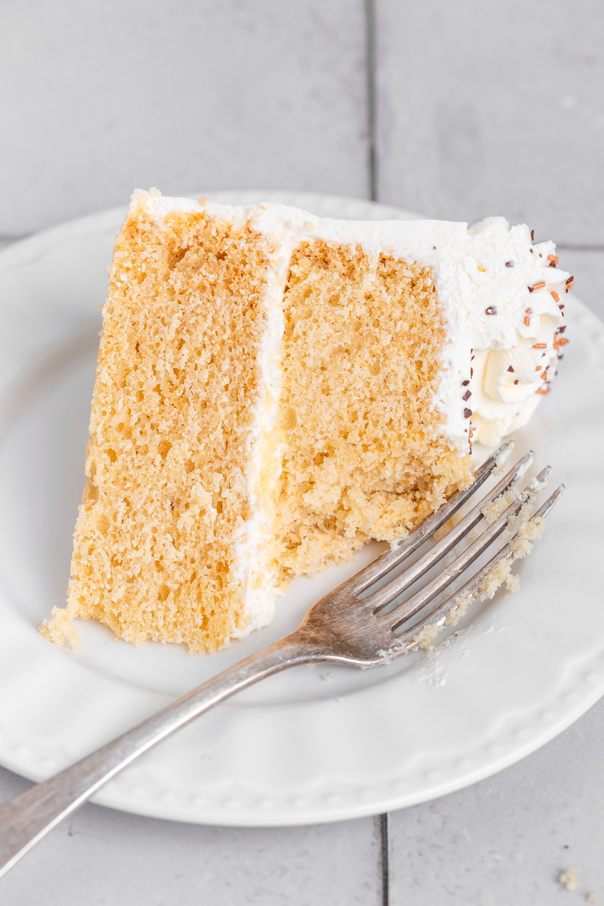 slice of vanilla cake on a plate with a fork