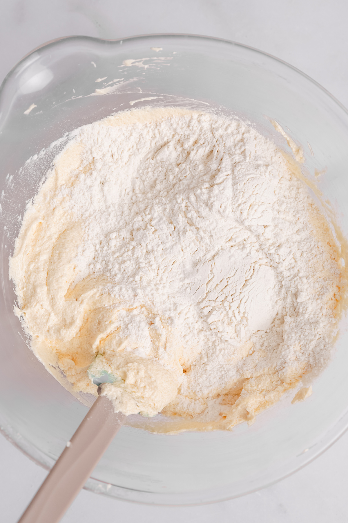 folding cake batter with flour mixture in a bowl