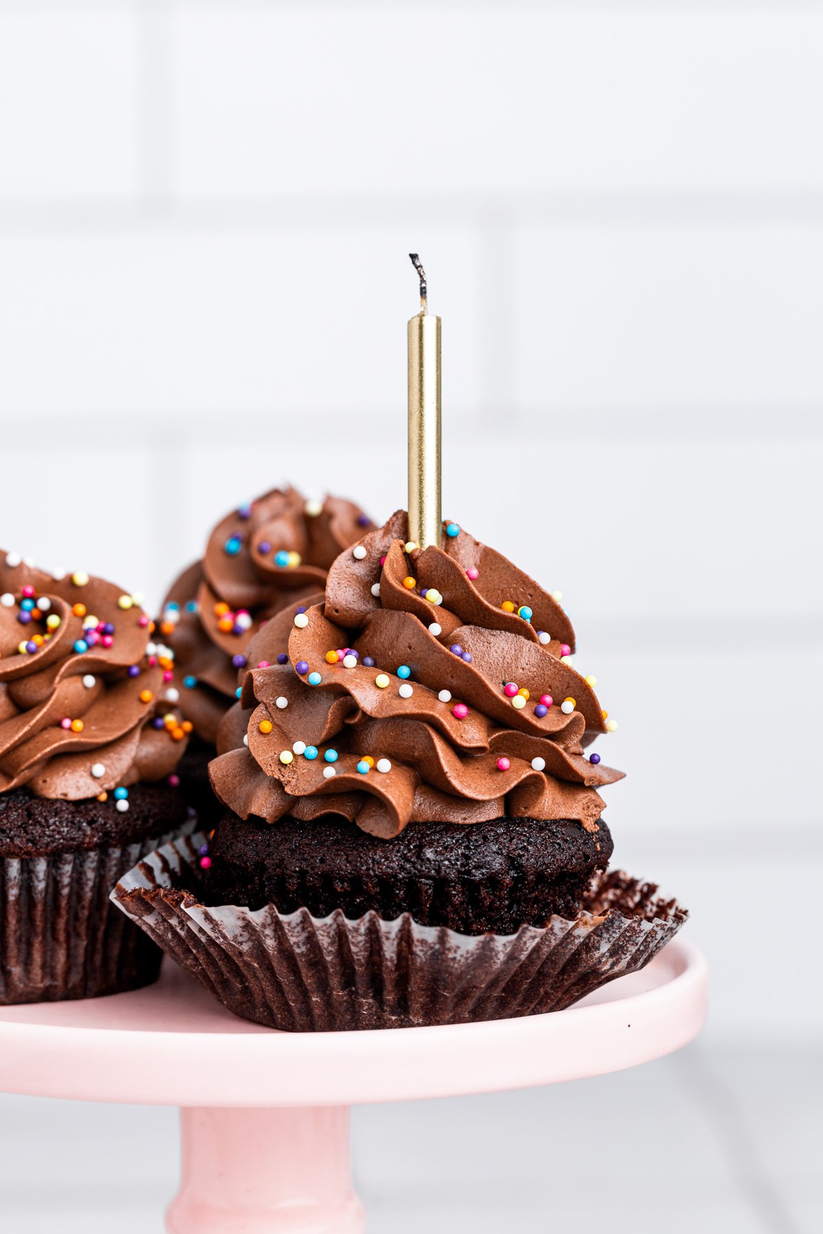 birthday chocolate cupcakes on a cake stand with chocolate buttercream