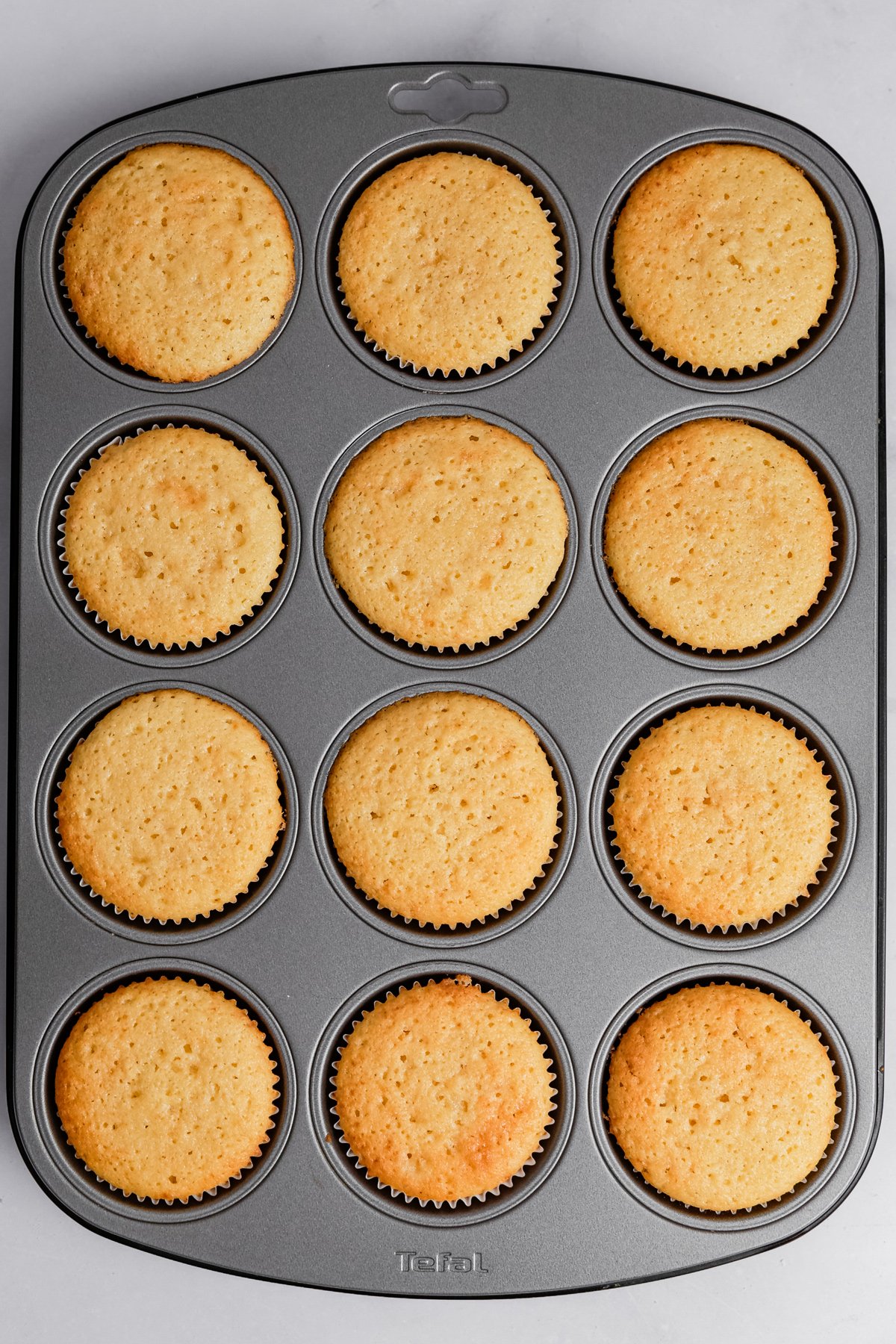 freshly baked vanilla cupcakes in a muffin pan
