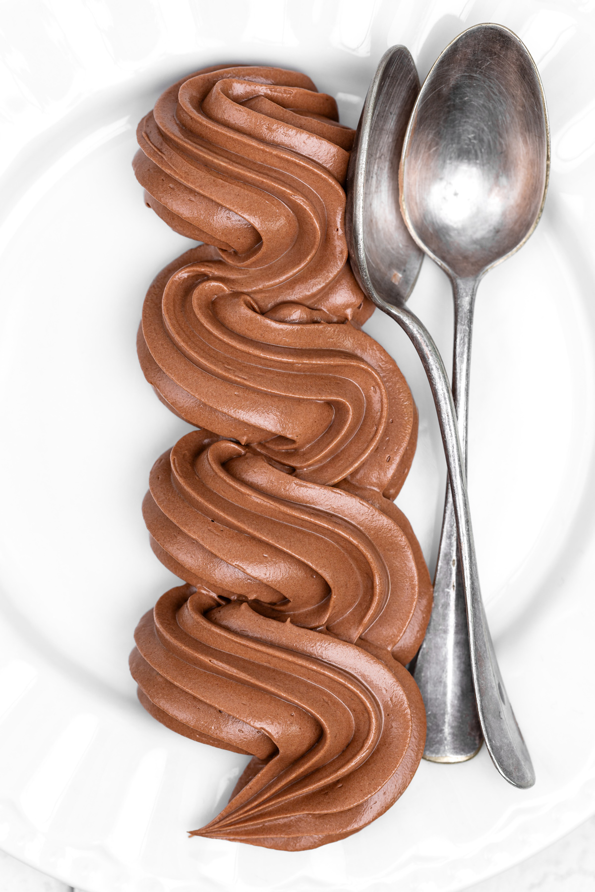 chocolate Swiss meringue buttercream piped with a piping bag on a plate