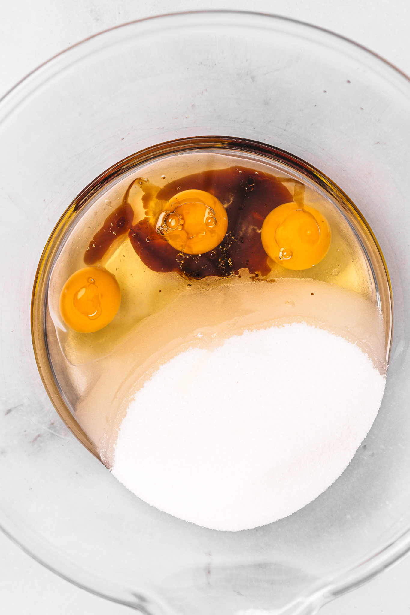 mixing eggs oil sugar and vanilla for chocolate sheet cake