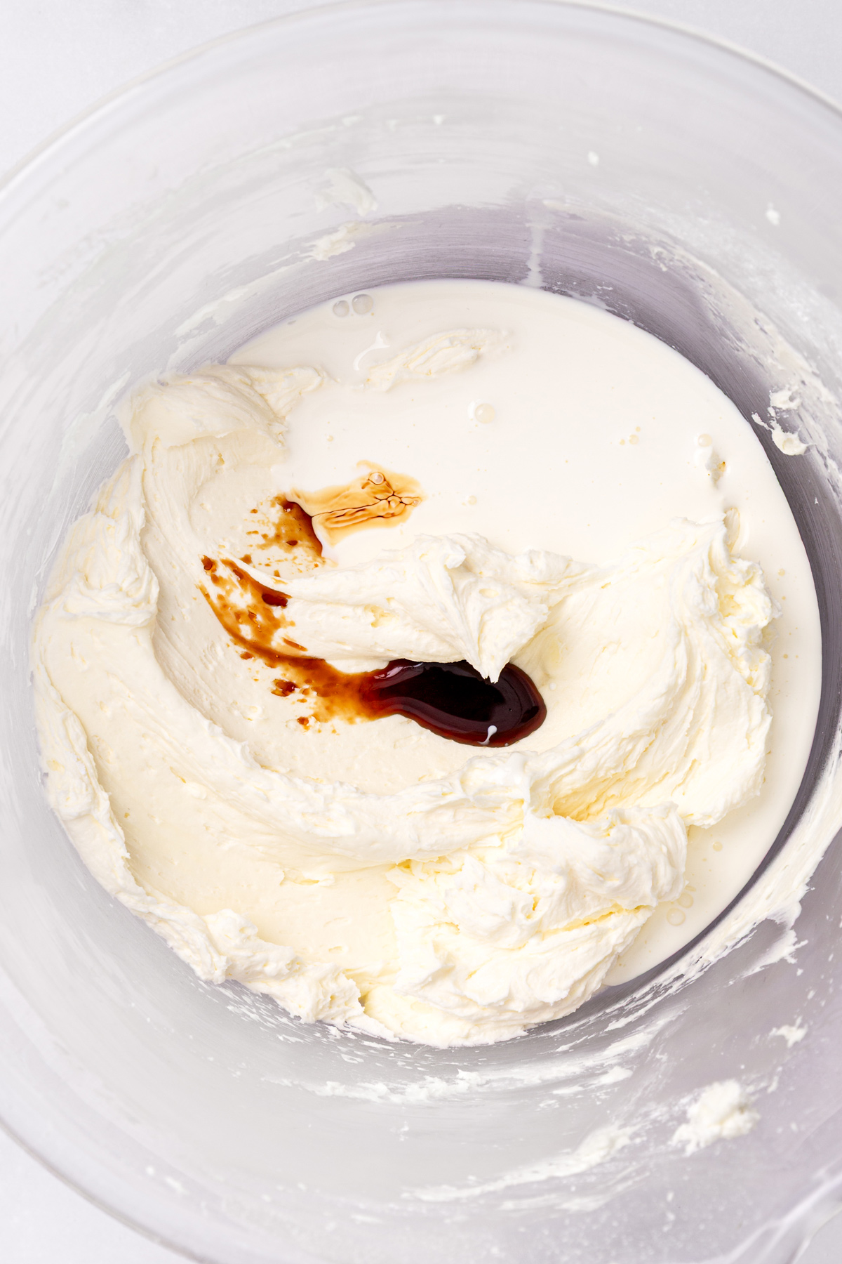 mixing heavy cream and vanilla into caramel buttercream