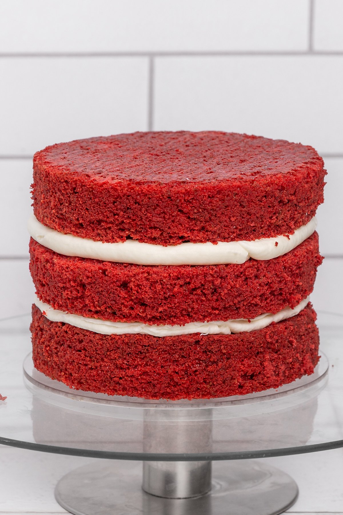 three layers of red velvet cake stacked with frosting