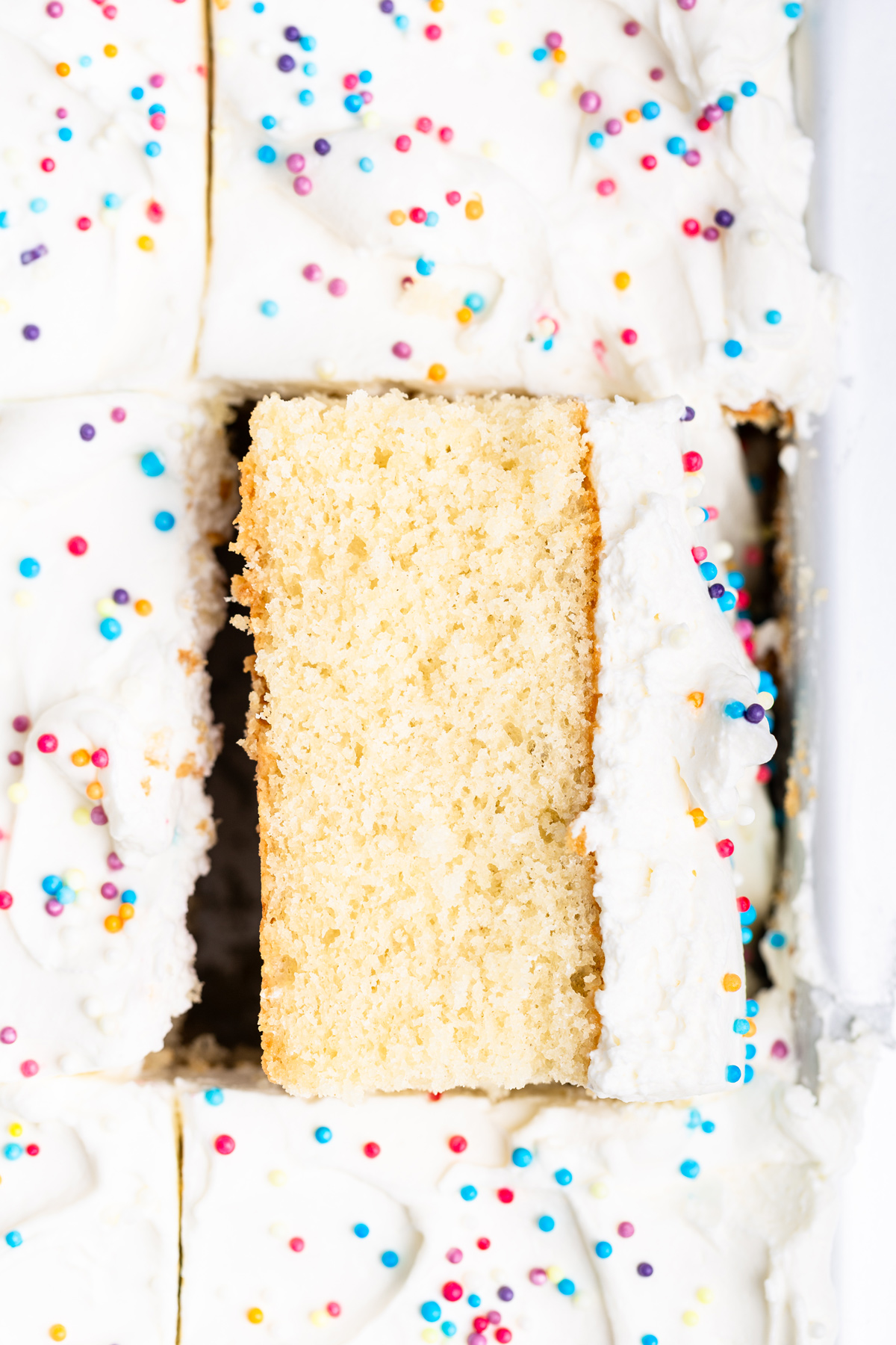 slice of vanilla sheet cake in baking pan