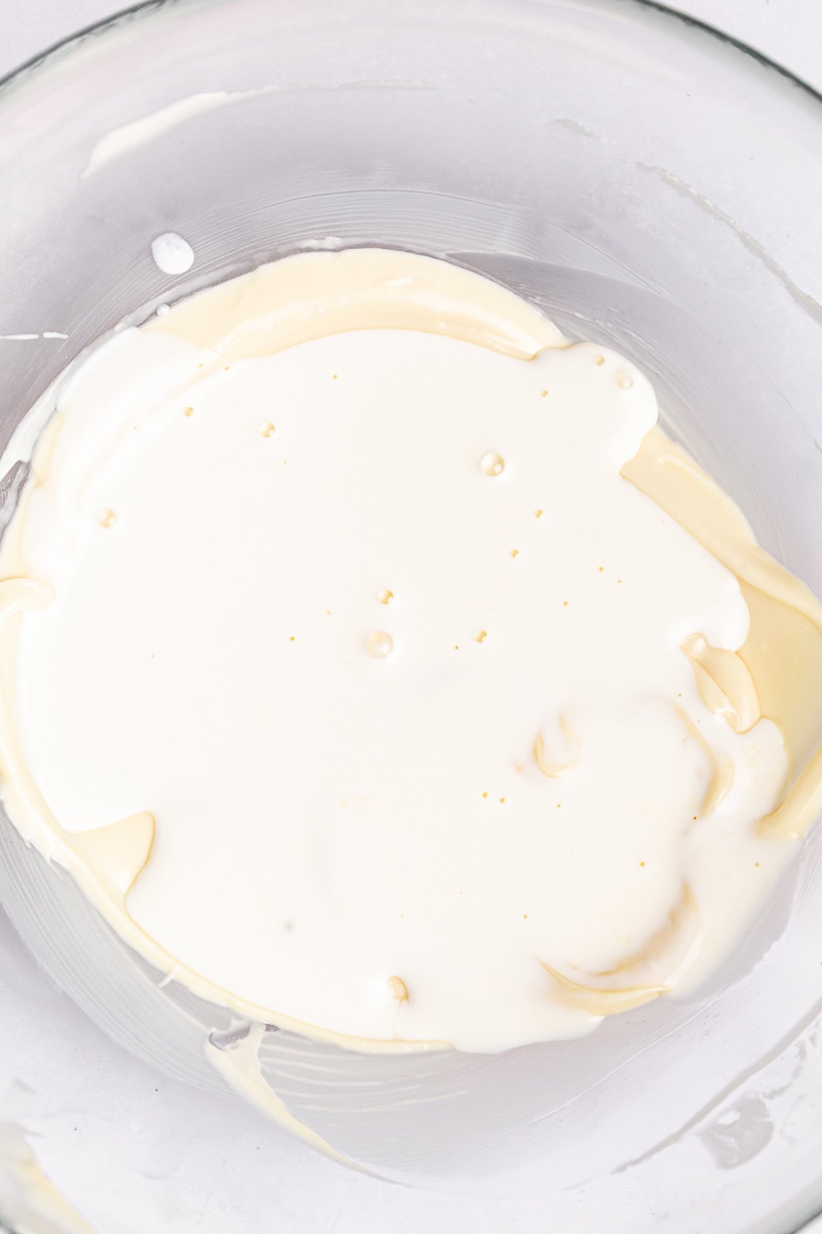 white chocolate ganache with melted chocolate and hot cream in bowl