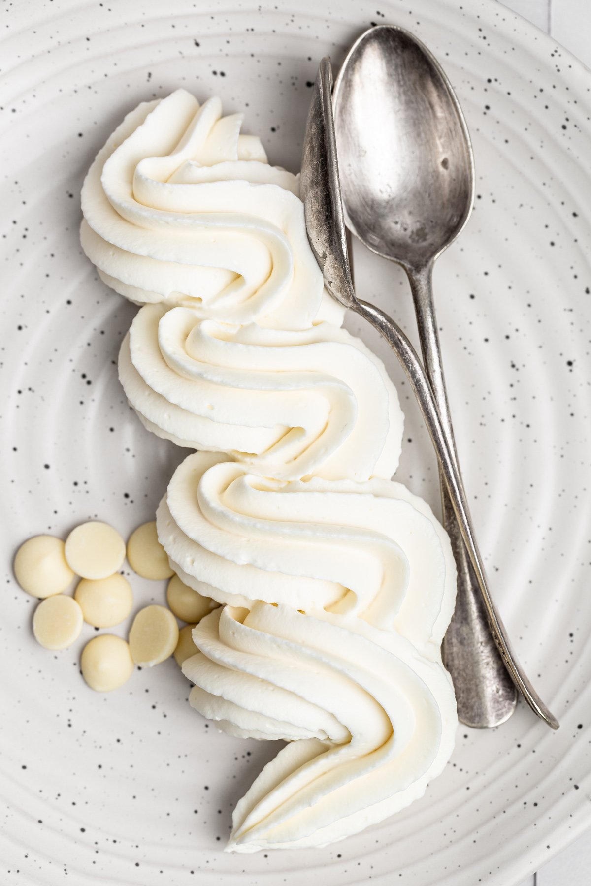 piped white chocolate ganache frosting on plate