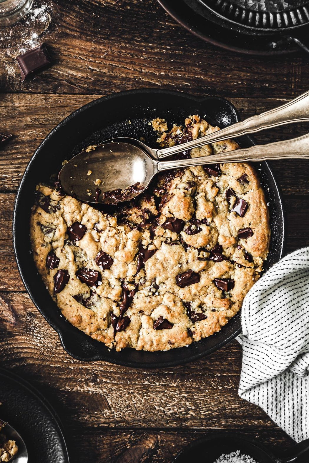 skillet chocolate chip cookie with gooey center served in cast iron pan with spoon