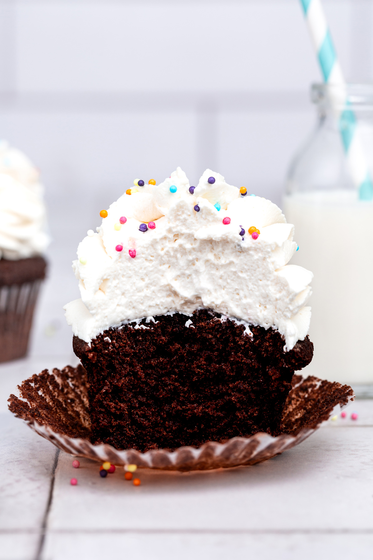 chocolate cupcake cut in half with vanilla frosting