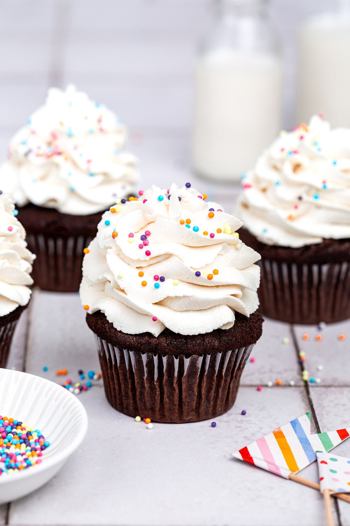 chocolate cupcakes with vanilla frosting on a table