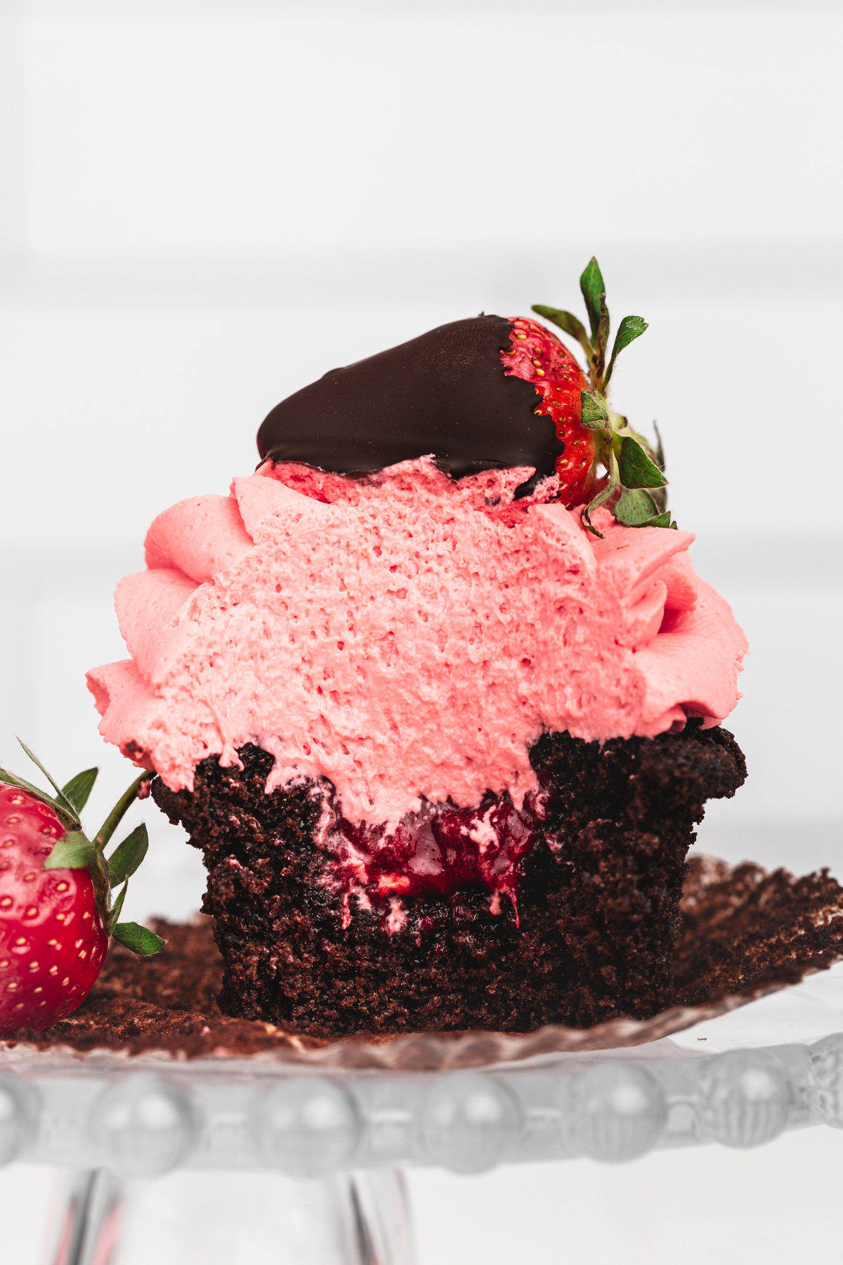 chocolate strawberry cupcake cut in half with strawberry compote filling inside