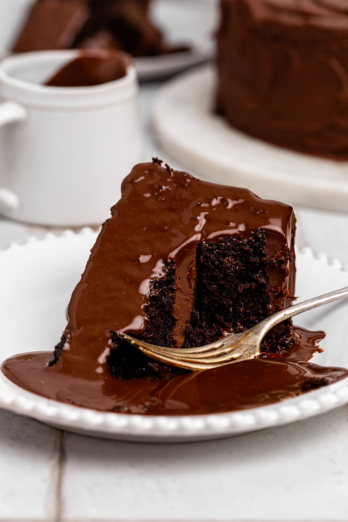 slice of matilda cake with chocolate sauce and fudge frosting